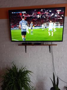 a television on a wall with a soccer game on it at CASA PARA ALQUILER LA LILI in Uspallata