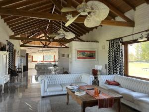 a living room with couches and a ceiling fan at Casa de campo en club privado in San Miguel del Monte