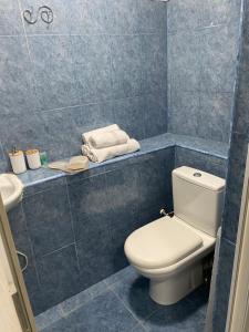 Baño de azulejos azules con aseo y lavamanos en Meidani Guest house en Tiflis