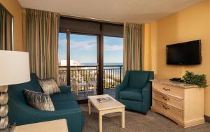 Una sala de estar con un sofá y sillas y un televisor. en Grande Shores Ocean Resorts Condominiums, en Myrtle Beach