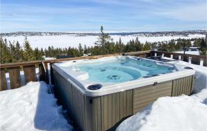 una bañera de hidromasaje en una terraza en la nieve en 5 Bedroom Gorgeous Home In Sjusjen en Sjusjøen