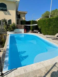 een blauw zwembad voor een huis bij Casa Milena elegante dimora con piscina privata in Albissola Marina