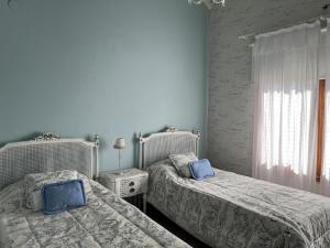 two beds in a bedroom with blue walls at Casa de campo en club privado Benquerencia in San Miguel del Monte