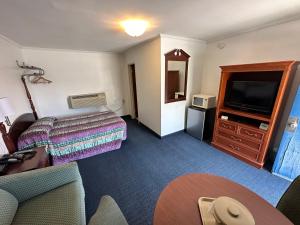 a hotel room with a bed and a television at Four Oaks Lodging in Smithfield