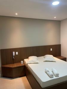 um quarto com uma cama com duas almofadas brancas em Hotel Max Tatuapé em São Paulo