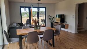 a dining room and living room with a table and chairs at Domek Osłonin in Osłonin