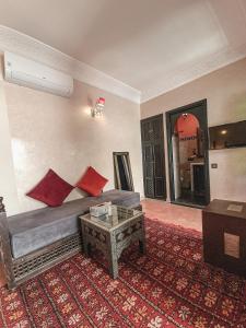 sala de estar con sofá y mesa en Riad Jaime, en Marrakech