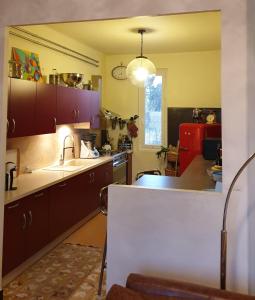 una cucina con armadi viola e piano di lavoro di St Rèmy de Provence, La Maison du Berger a Saint-Andiol