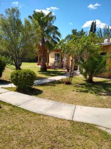 una casa con una palmera y una acera en Casa Rural en San Rafael con pileta, en San Rafael