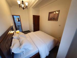1 dormitorio con 1 cama con sábanas y almohadas blancas en Résidence M Douala, en Douala