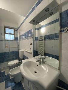 Un baño con lavabo, inodoro y espejo. en La Casa di Nora, en Turín 18 fotos más