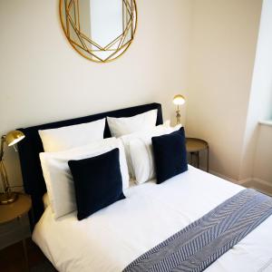 a bedroom with a white bed with blue pillows at The Snug in Dunoon