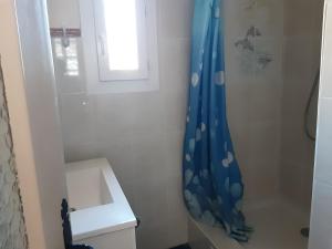 uma casa de banho com um chuveiro com uma cortina de chuveiro azul em Mihechris em Collioure