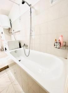 bagno bianco con vasca e doccia di Daruma Apartment a Siniscola