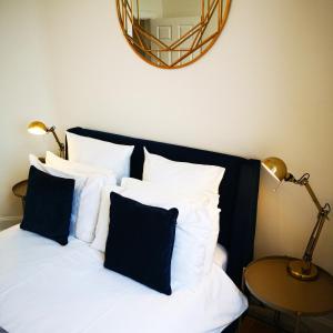 a bed with black and white pillows and a mirror at The Snug in Dunoon