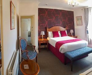 a bedroom with a large bed with a red headboard at Annabelle Rooms in Great Yarmouth