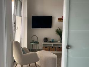 sala de estar con 2 sillas y TV en la pared en Pearl 7 Nordsee Park Dangast, en Dangast