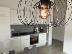 una cocina con una luz colgada del techo en Pearl 7 Nordsee Park Dangast, en Dangast