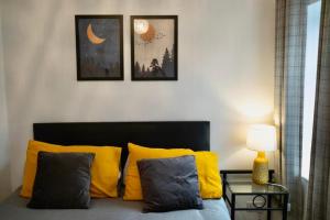 a bed with yellow and grey pillows in a room at TwentyQC in Derry Londonderry