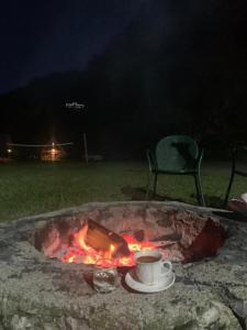 eine Feuerstelle mit einer Tasse Kaffee und einem Stuhl in der Unterkunft Villa Restaurant Mulliri in Peja