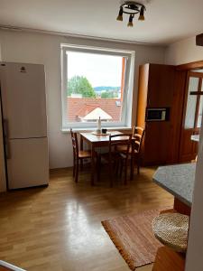 a kitchen with a table and chairs and a window at Apartmán MW in Poprad