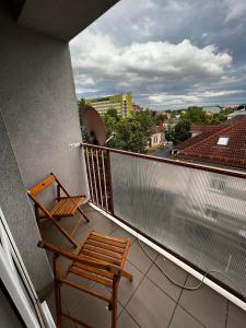 a chair on a balcony with a view of a city at Apartmán MW in Poprad