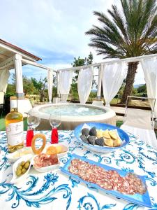 - une table avec des assiettes de nourriture et une piscine dans l'établissement Villa Bianca, à Tertenìa