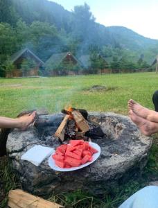 a plate of watermelon on top of a camp fire at Villa Restaurant Mulliri in Peje