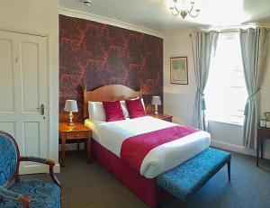 a bedroom with a bed with a red wall at Annabelle Rooms in Great Yarmouth