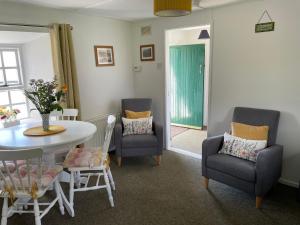 a living room with a table and chairs and a dining room at Anne’s Thatched Cottage in Kilcar +14 photos