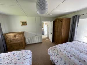 a bedroom with a bed and a dresser and a window at Anne’s Thatched Cottage in Kilcar