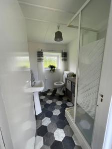 y baño con aseo, lavabo y ducha. en Anne’s Thatched Cottage, en Kilcar