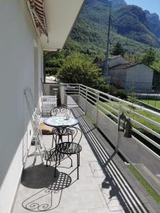 patio con mesa y sillas en el balcón en Mountain View House, en San Cassiano