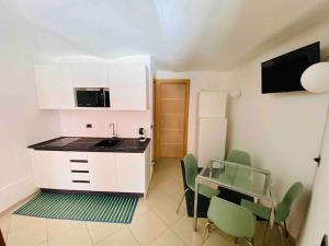 a kitchen with a table and chairs and a microwave at Casa Macrino Apartment Alba in Alba