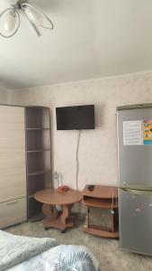 a room with a table and a tv on a wall at " Na golubom ozere" in Kamianske