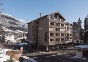 un edificio nel mezzo di una città con la neve di Hotel des Alpes a Flims