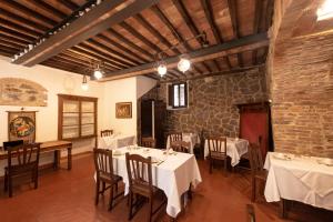 a restaurant with tables and chairs and a brick wall at IL PALAZZO DEL CARDINALE in Montalcino