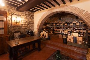 Zimmer mit einem Tisch und einer Wand aus Weinflaschen in der Unterkunft IL PALAZZO DEL CARDINALE in Montalcino