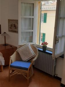 een rieten stoel in een kamer met een raam bij Casa Francesca, vicino al mare in Sestri Levante