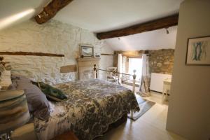 a bedroom with a bed and a stone wall at Gorgeous romantic cosy cottage retreat with views in Winster