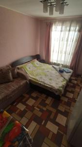 - une chambre avec un lit, un canapé et une fenêtre dans l'établissement " Na golubom ozere", à Kamianske