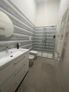 Un baño con lavabo, inodoro y ducha. en Dimora Chiaia 209, en Nápoles