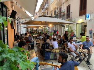 un grupo de personas sentadas en un restaurante al aire libre en Sicily Home-affittacamere mediterraneo, en Marsala