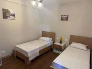 Duas camas num pequeno quarto com paredes brancas em Vila Alba em Korçë