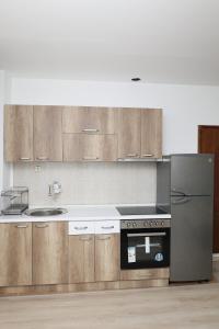 a kitchen with wooden cabinets and a stainless steel refrigerator at Gramosli Apartment in Bitola