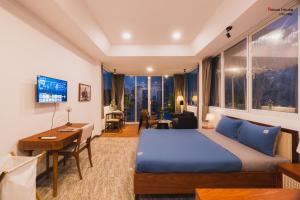 a hotel room with a bed and a desk and a room at Nexus House Cây Điệp in Ho Chi Minh City