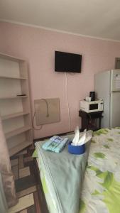 Habitación con cama y TV en la pared. en " Na golubom ozere" en Dniprodzerzhynsʼk