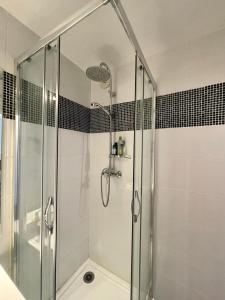 een douche met een glazen deur in de badkamer bij Bara by Yumē in Toulouse