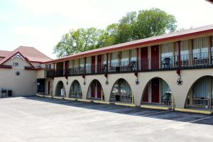 a large building with arches and balconies on it at Executive Inn Goliad in Goliad