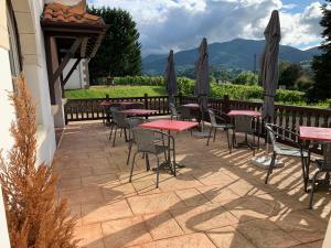 a patio with tables and chairs with mountains in the background at Villa Harriet in Uhart-Cize